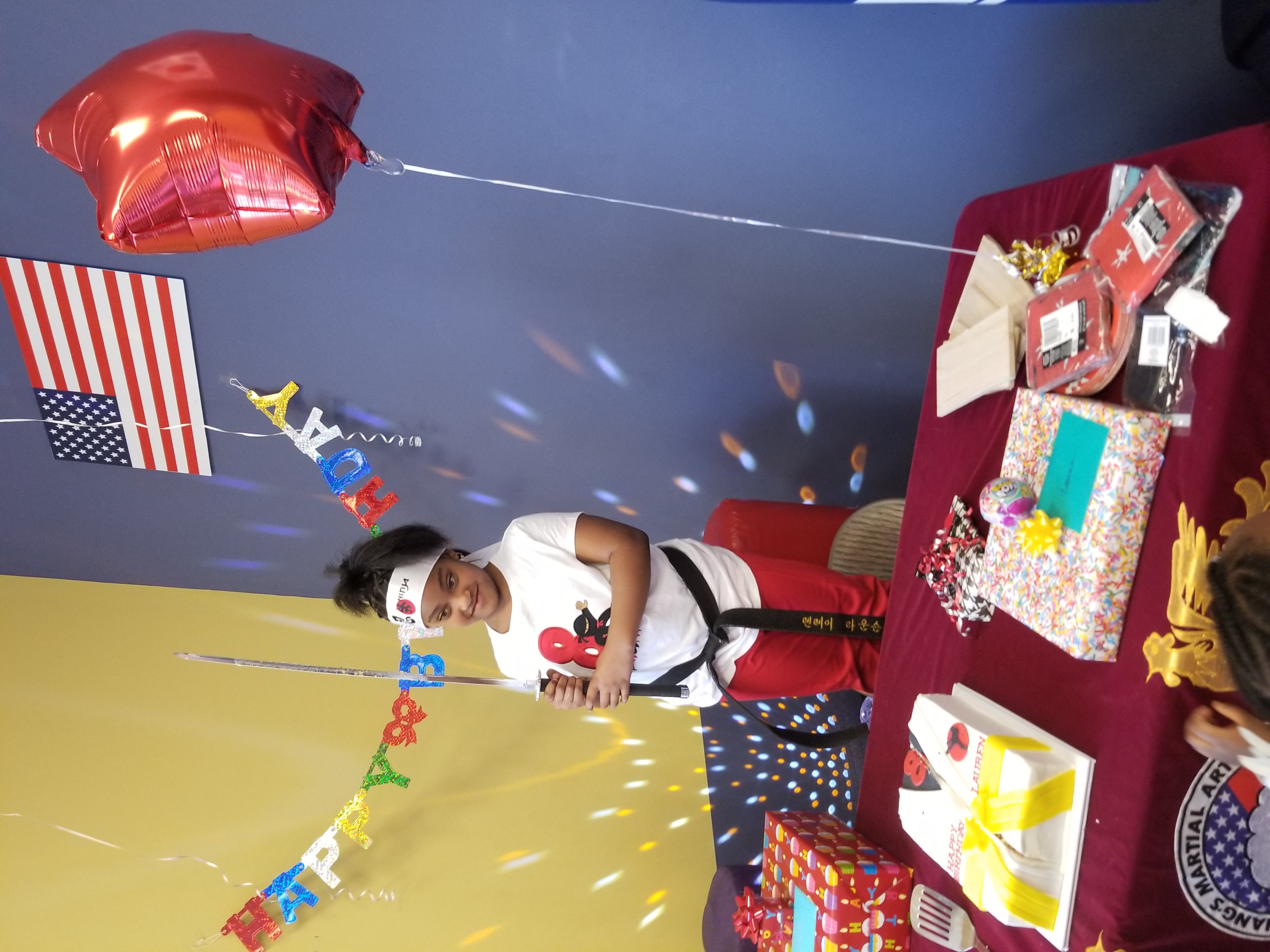 Birthday celebrant holding the Samurai sword for the cake-cutting experience at Attack Taekwondo