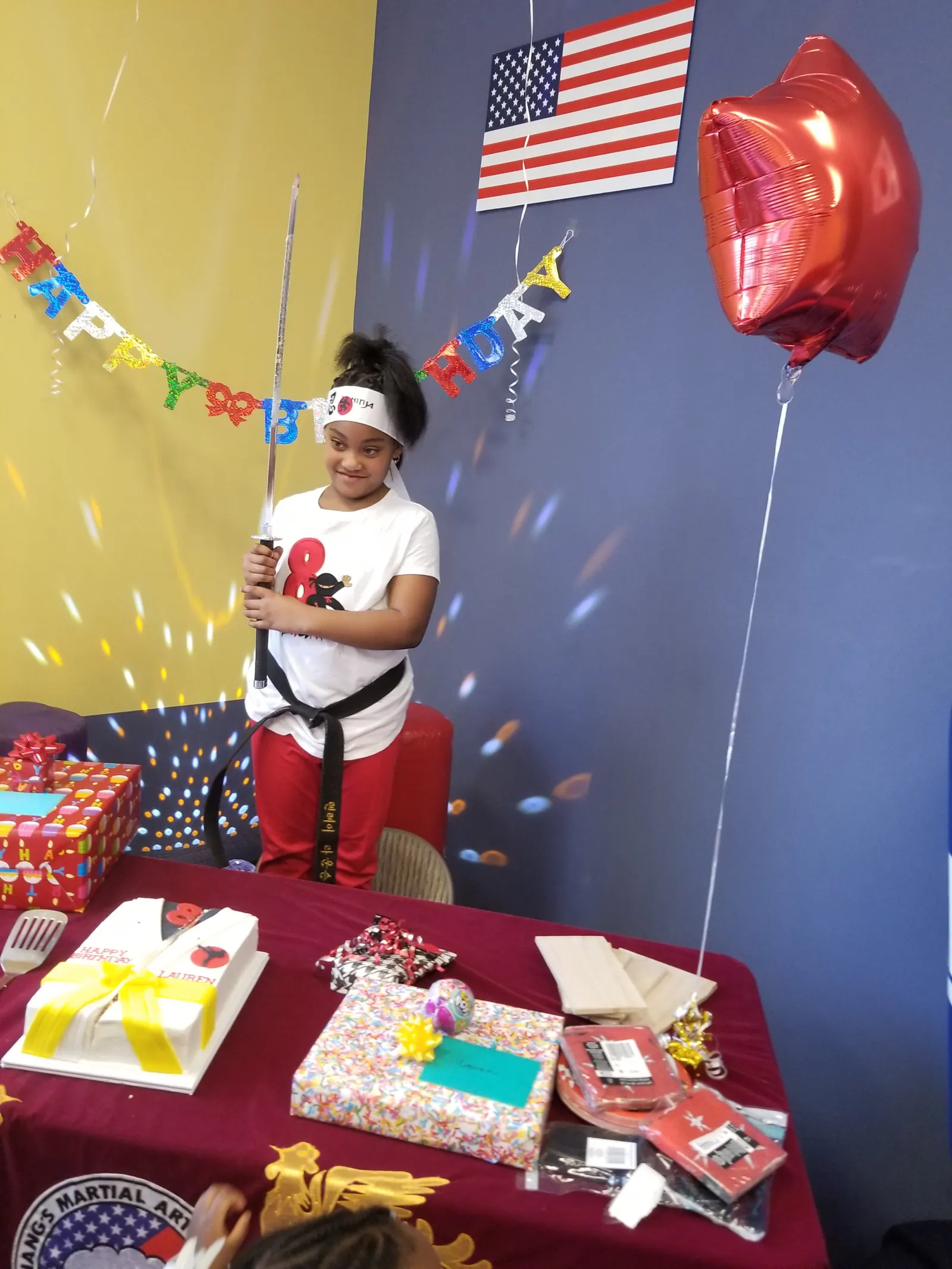 Birthday celebrant holding the Samurai sword for the cake-cutting experience at Attack Taekwondo