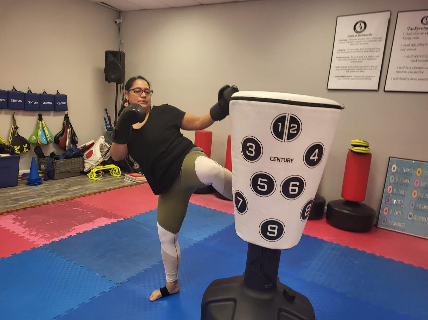 Turbulence member performing a side kick on a training bag